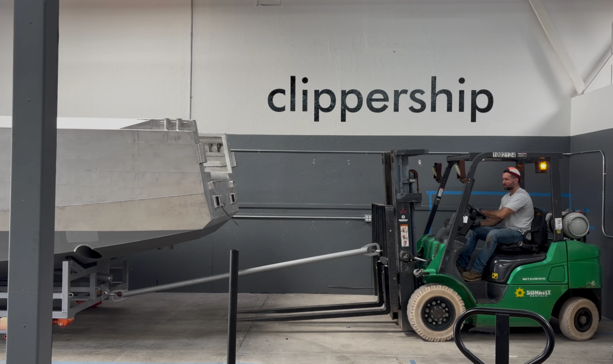 Hull towed by forklift past the Clippership wordmark